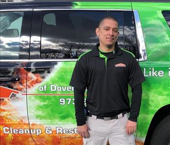 man in black shirt and khaki pants standing in front of a truck