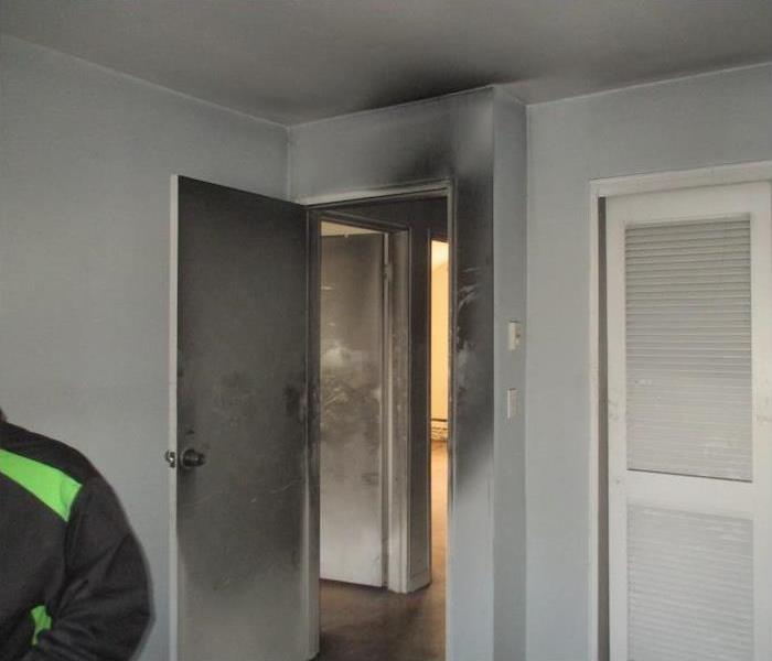 soot damage on a wall and door of a bedroom